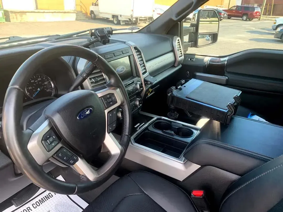 The interior of a ford truck with a steering wheel and dashboard.