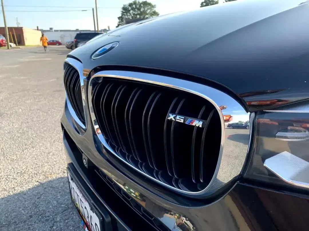 The front grille of a black bmw x5 m is shown