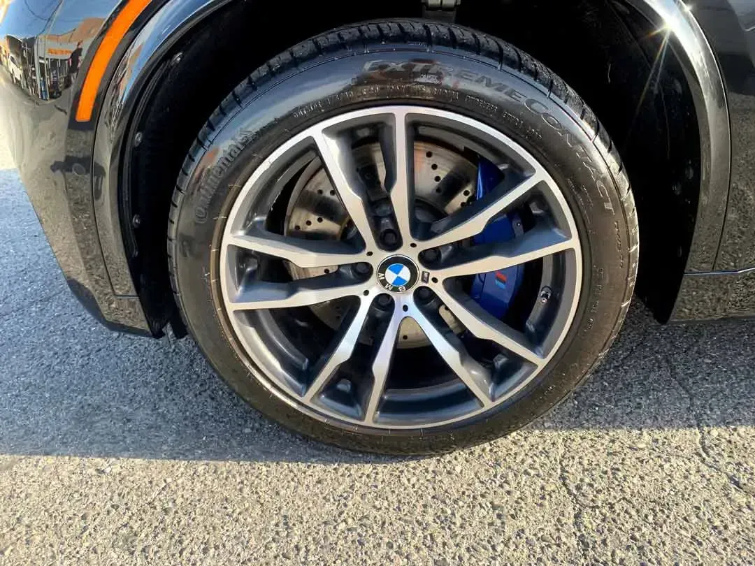 A close up of a car wheel on a road.