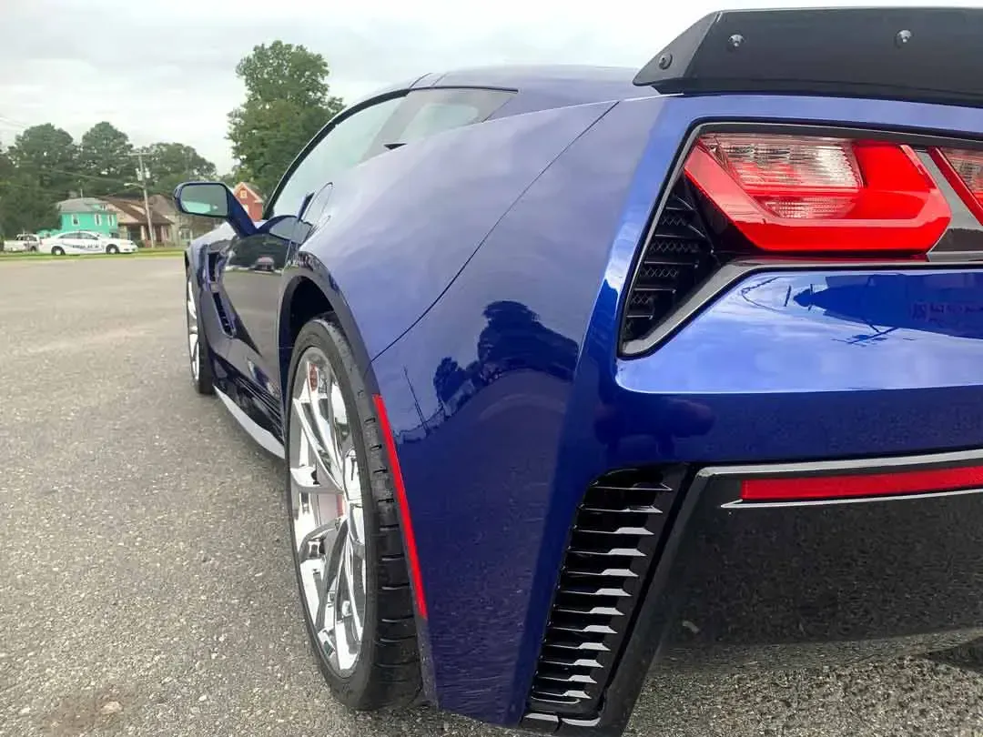A blue sports car is parked in a parking lot