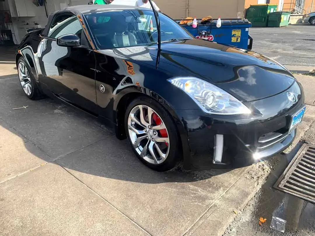 A black sports car is parked on the side of the road.