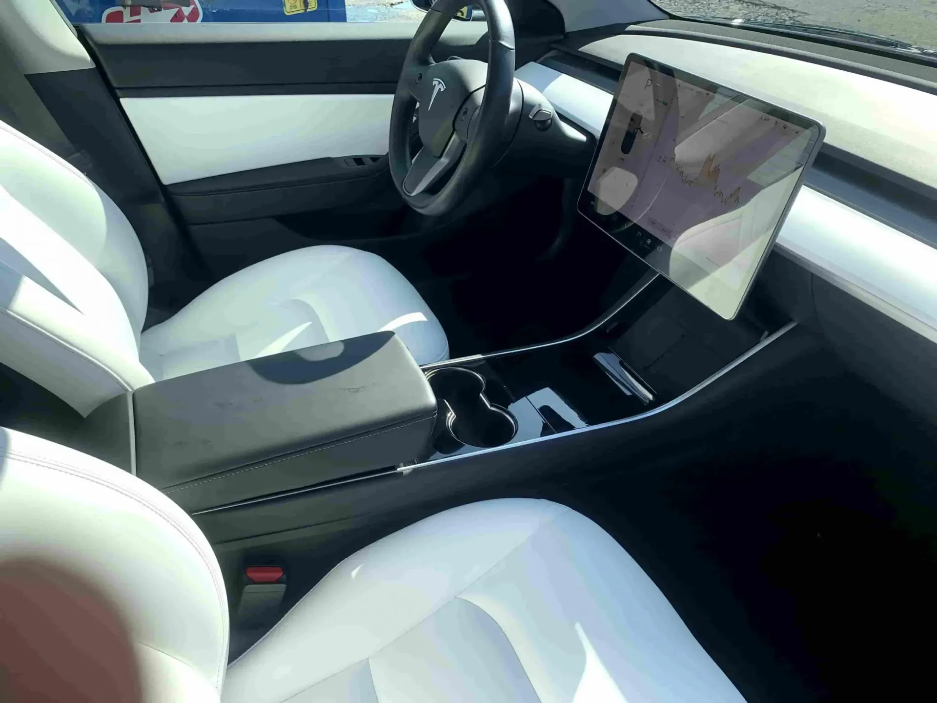The inside of a tesla model 3 with white seats