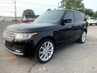 A black range rover is parked in a parking lot.