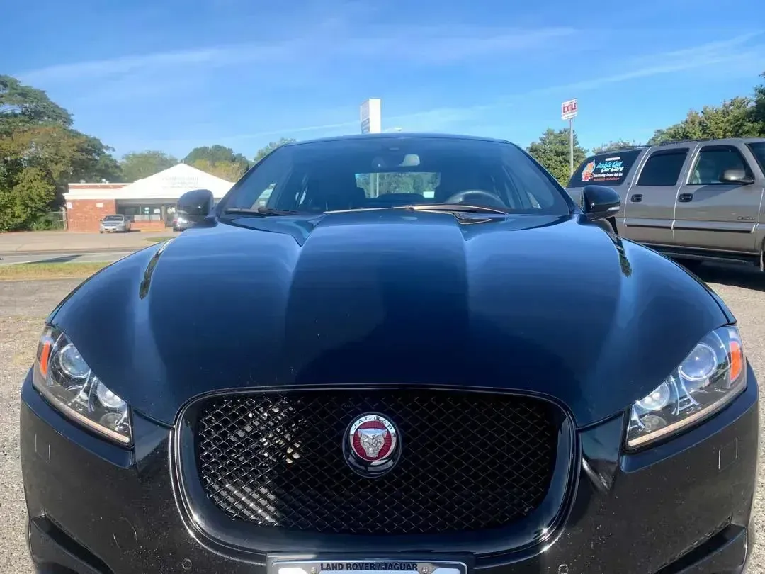 A black jaguar f type is parked in a parking lot.