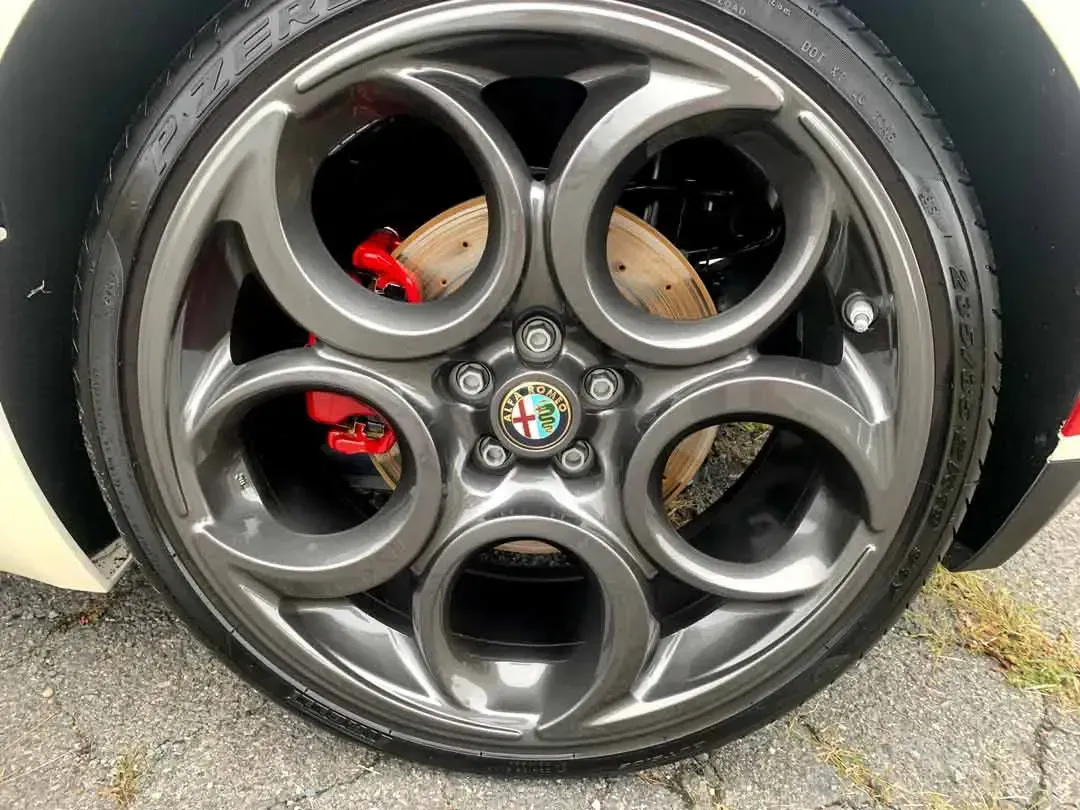 A close up of a car wheel with red brake calipers.