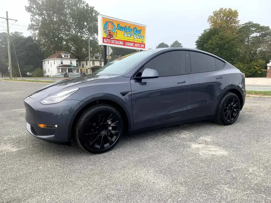 A tesla model y is parked in a parking lot.