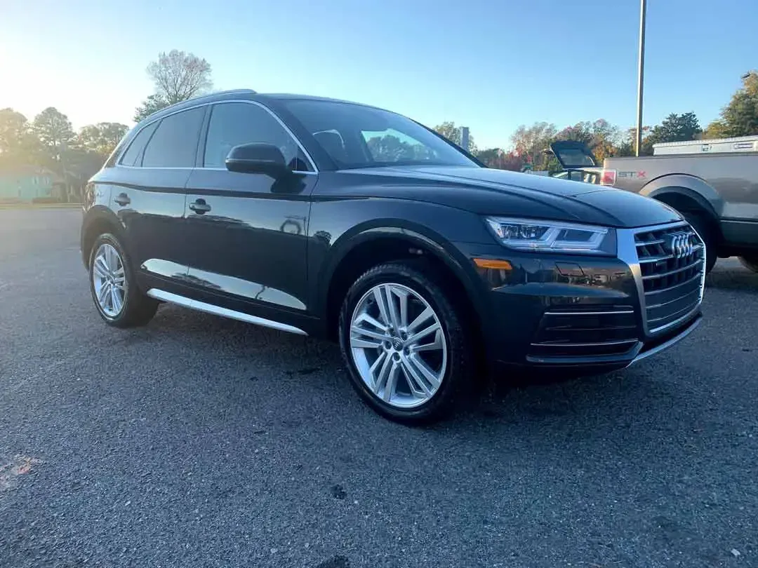 A black audi q5 is parked in a parking lot.