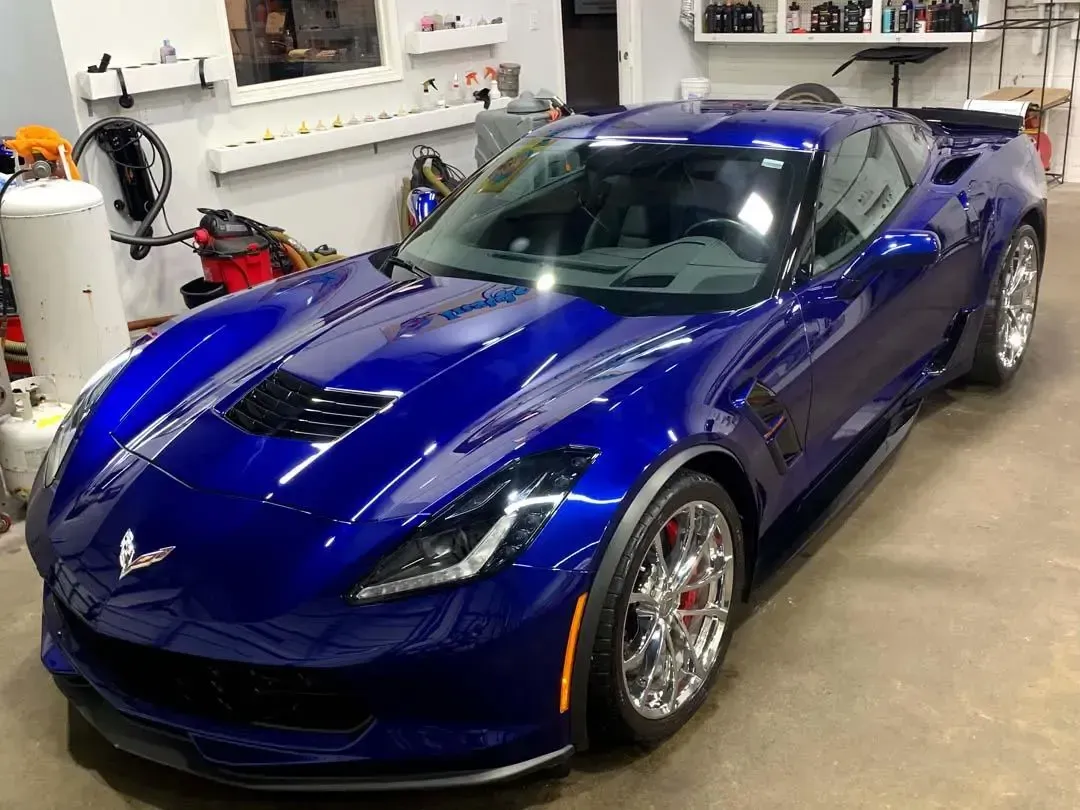A blue sports car is parked in a garage.