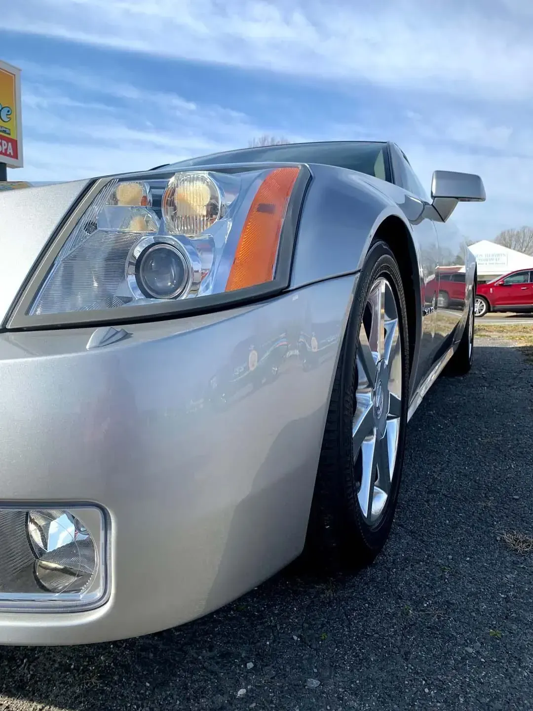 A silver car is parked on the side of the road.