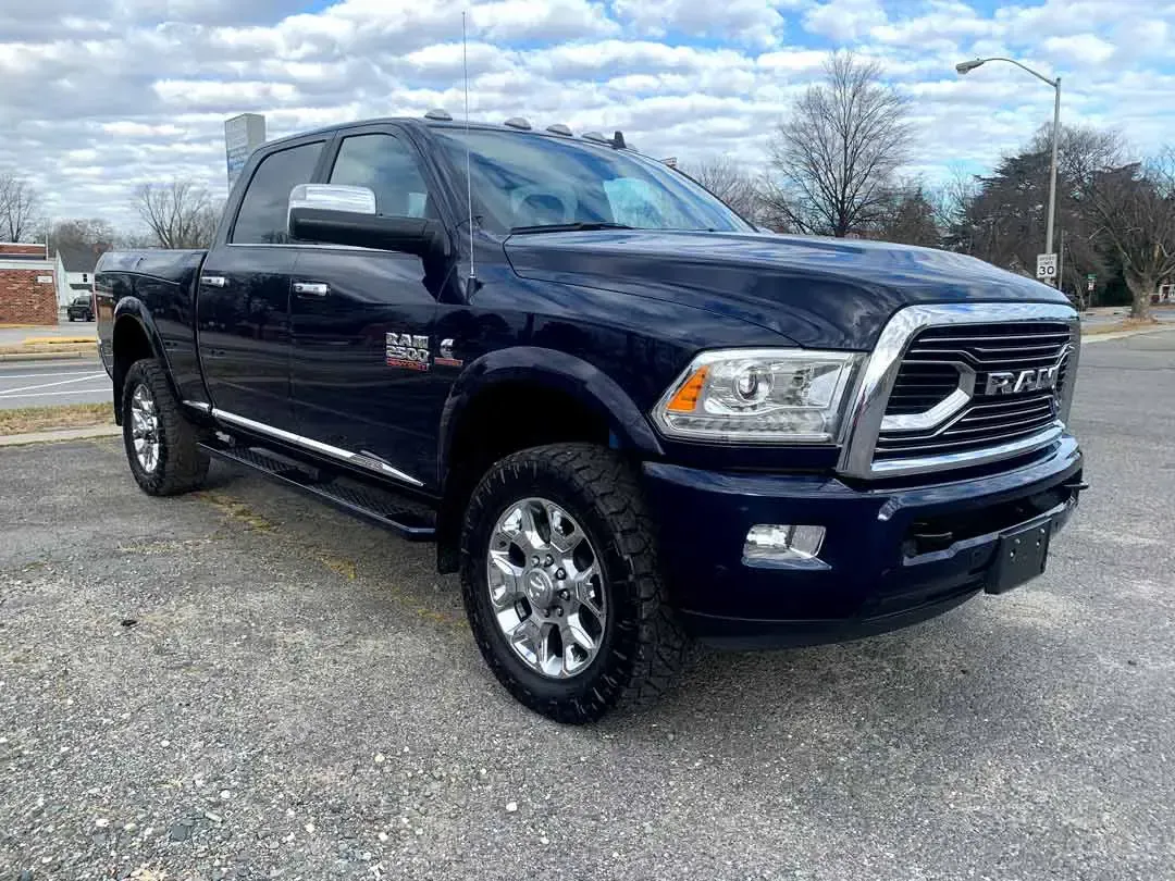 A blue ram truck is parked in a parking lot.