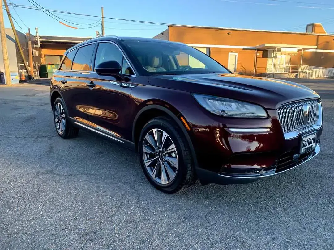 A burgundy lincoln aviator is parked in front of a building.