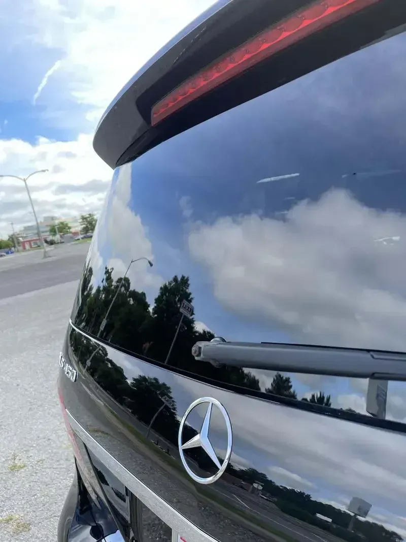 A black mercedes is parked on the side of the road