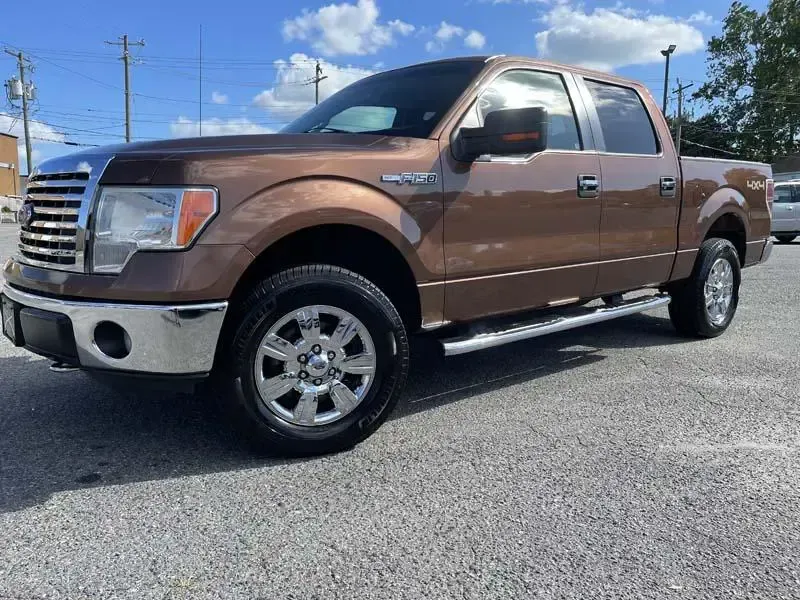 A brown ford f150 truck is parked in a parking lot.