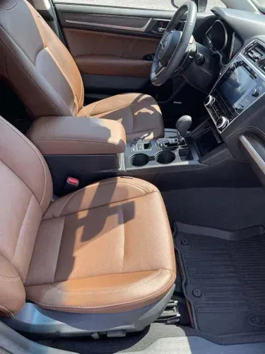 The interior of a car with brown leather seats and a steering wheel.