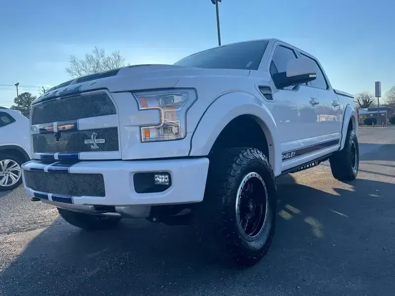 A white ford f150 is parked in a parking lot.