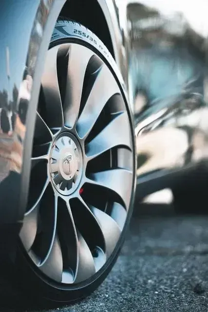 A close up of a car wheel with a fan design