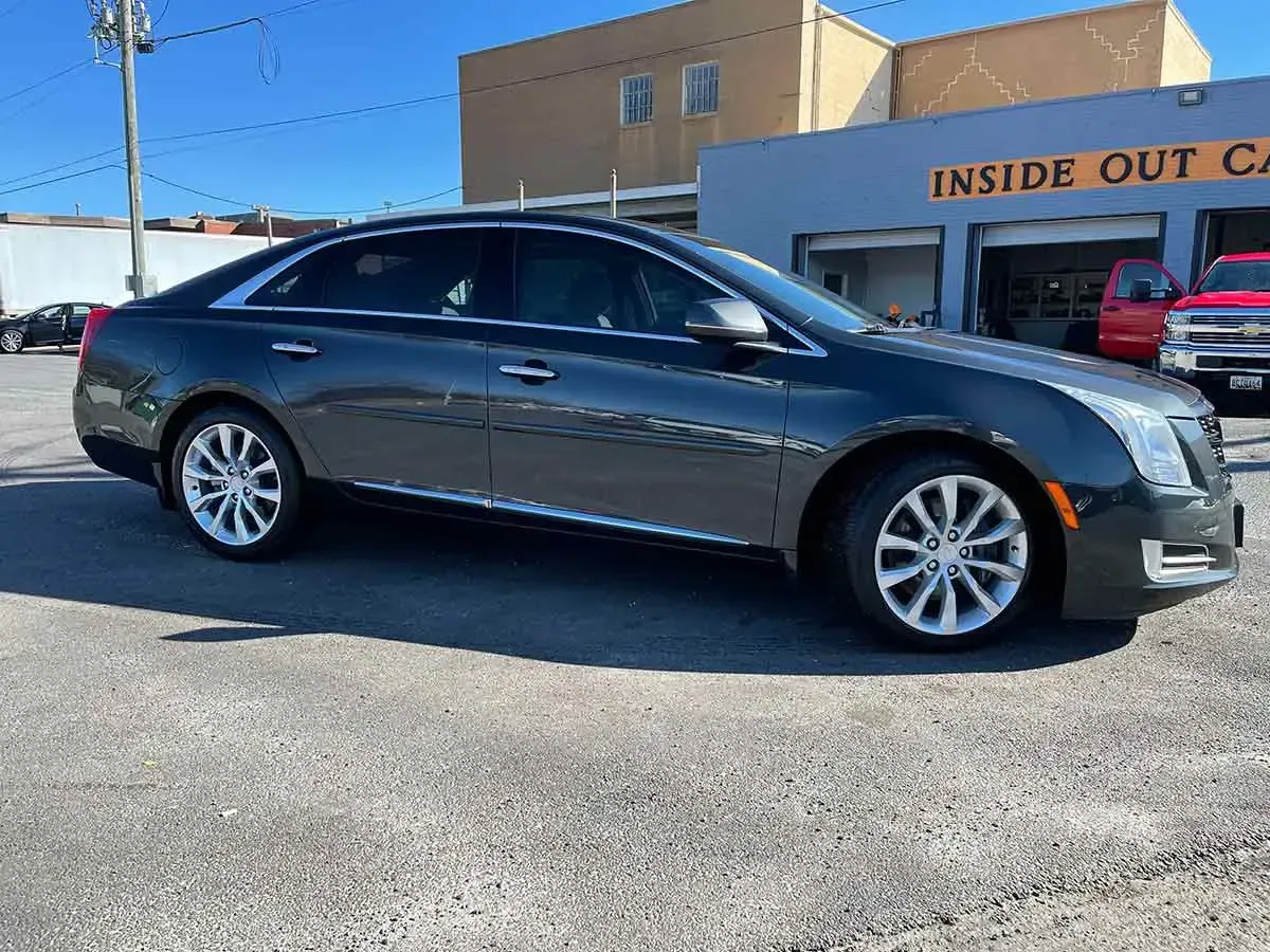 A black cadillac cts is parked in front of a building.
