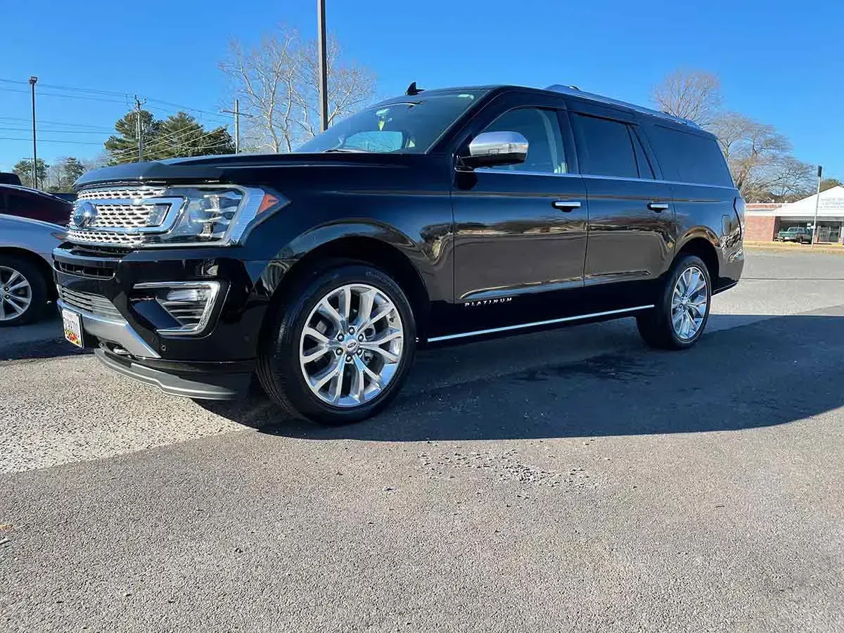 A black ford expedition is parked in a parking lot.