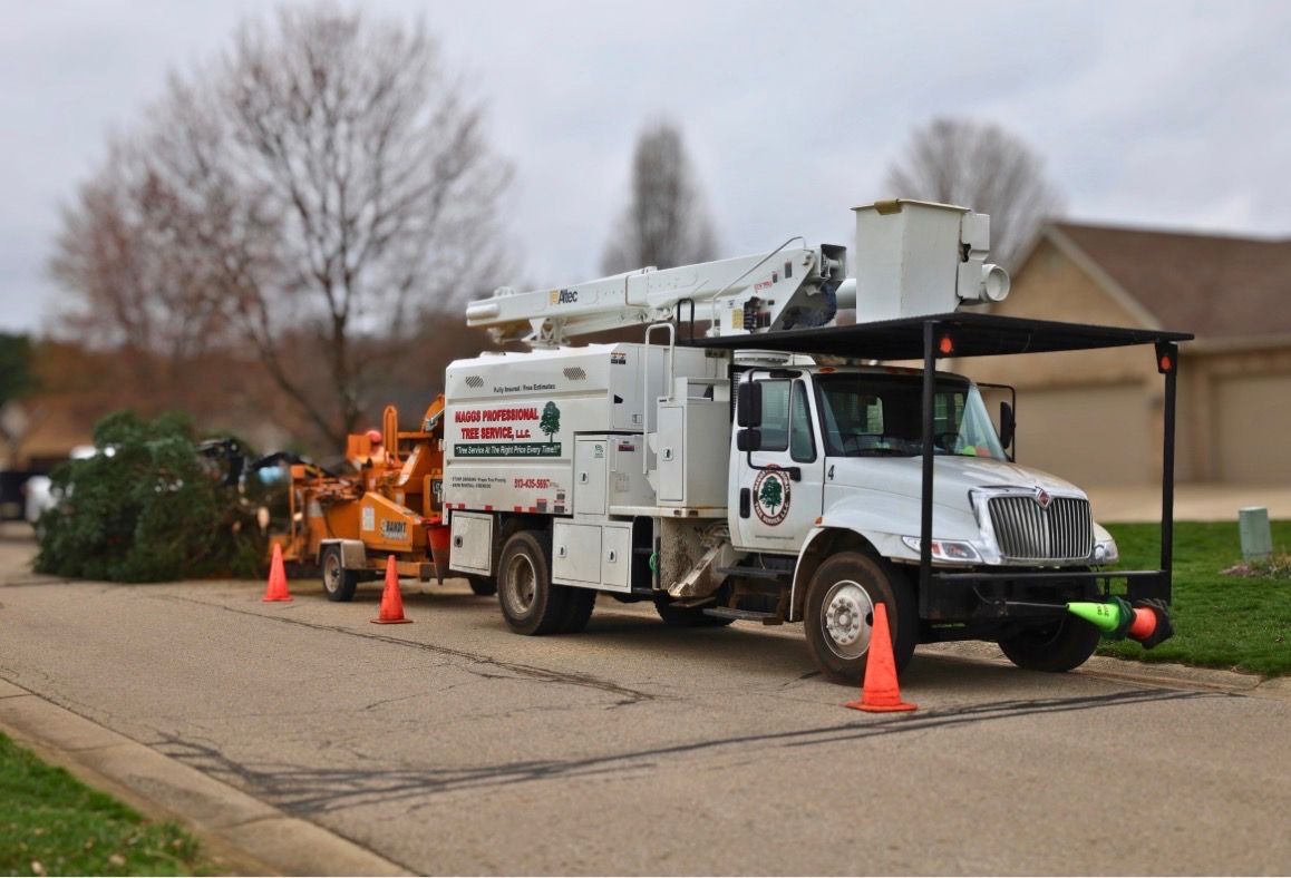 A large tree has fallen and broken through a white vinyl privacy fence in a grassy yard.