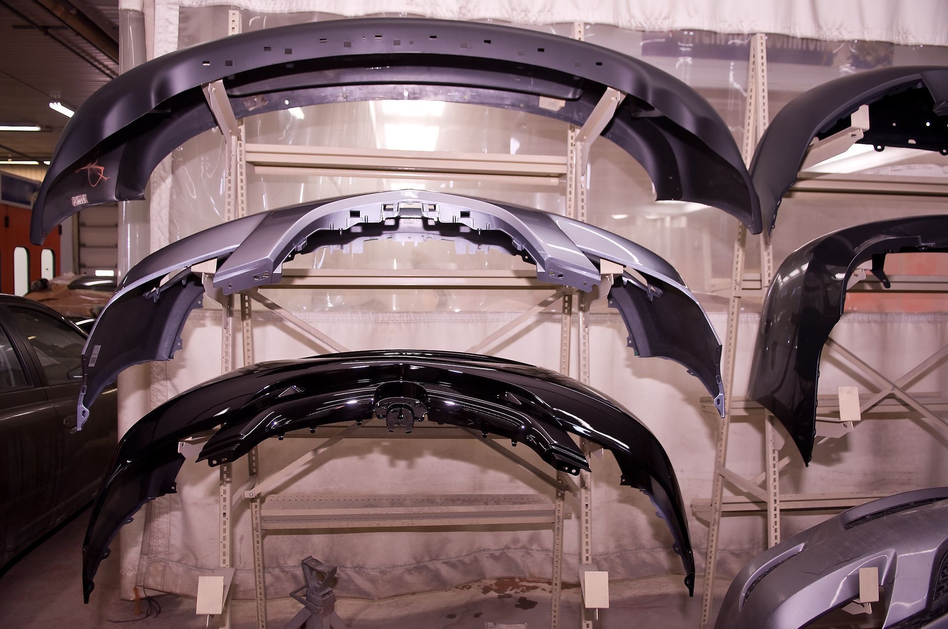 Car bumpers displayed on shelves in a warehouse.