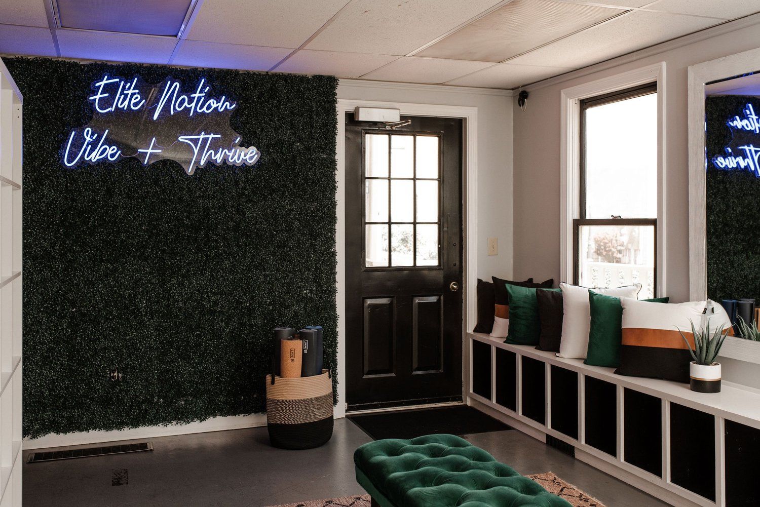 Inside a studio, a green wall and a door. Neon sign: 
