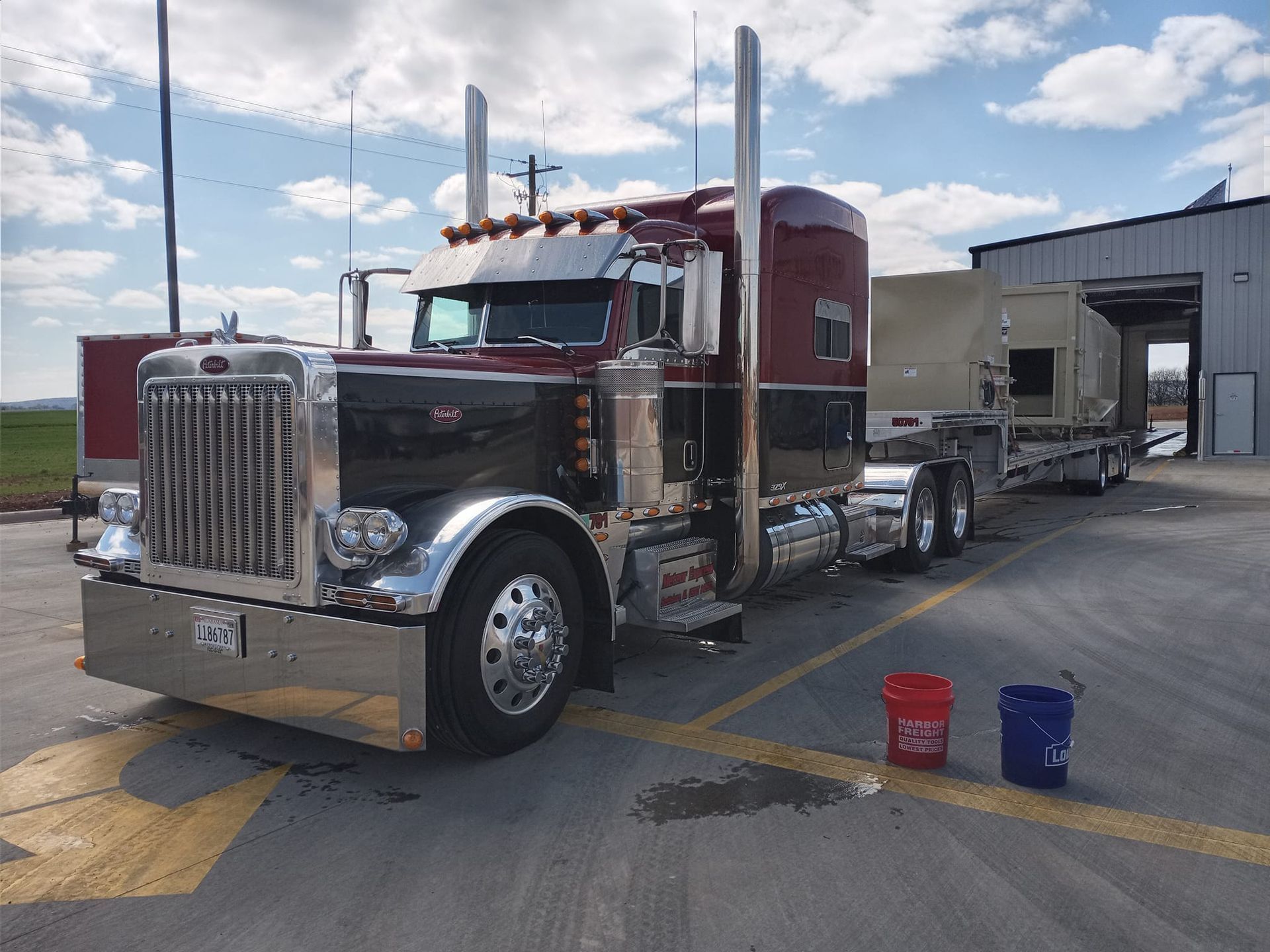 a large semi truck is parked in a parking lot next to a building .
