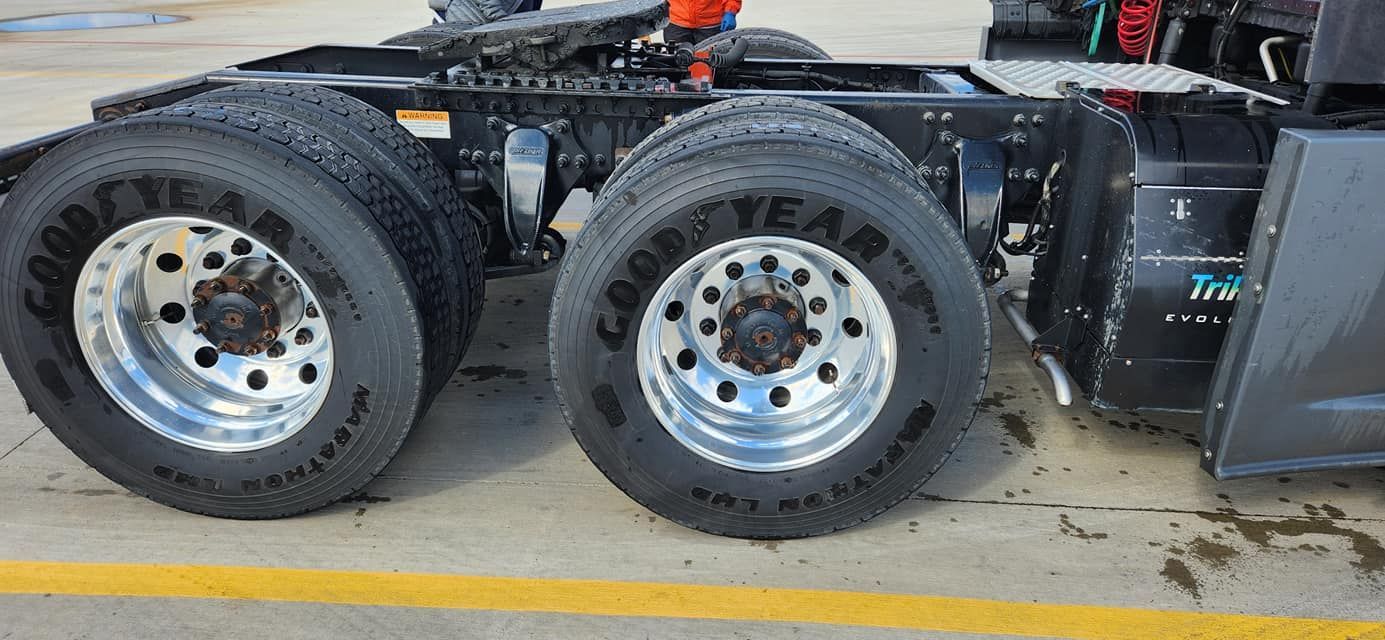a semi truck with good year tires is parked in a parking lot .