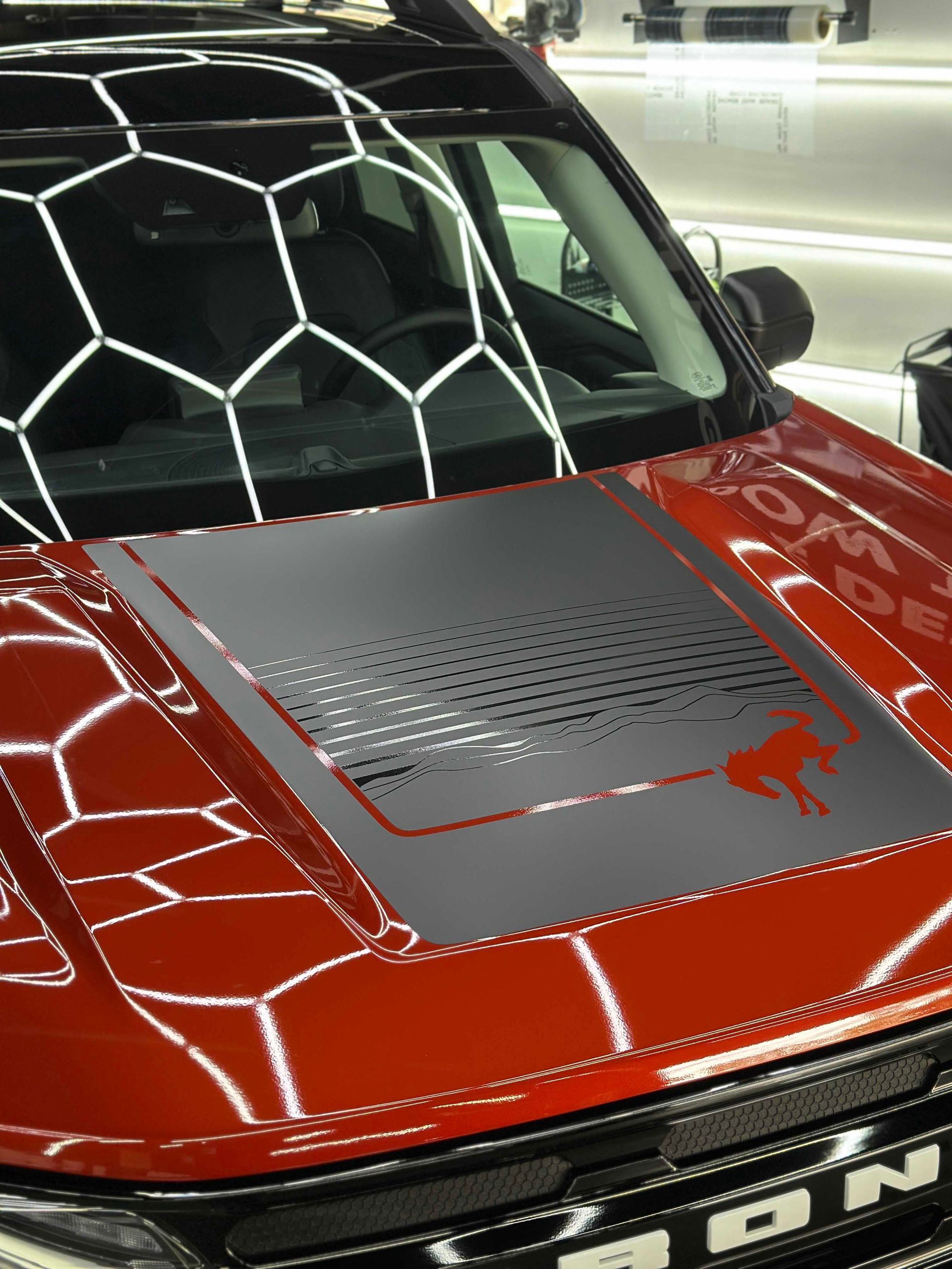 Red Ford Bronco Sport with hood decal featuring a horse silhouette.