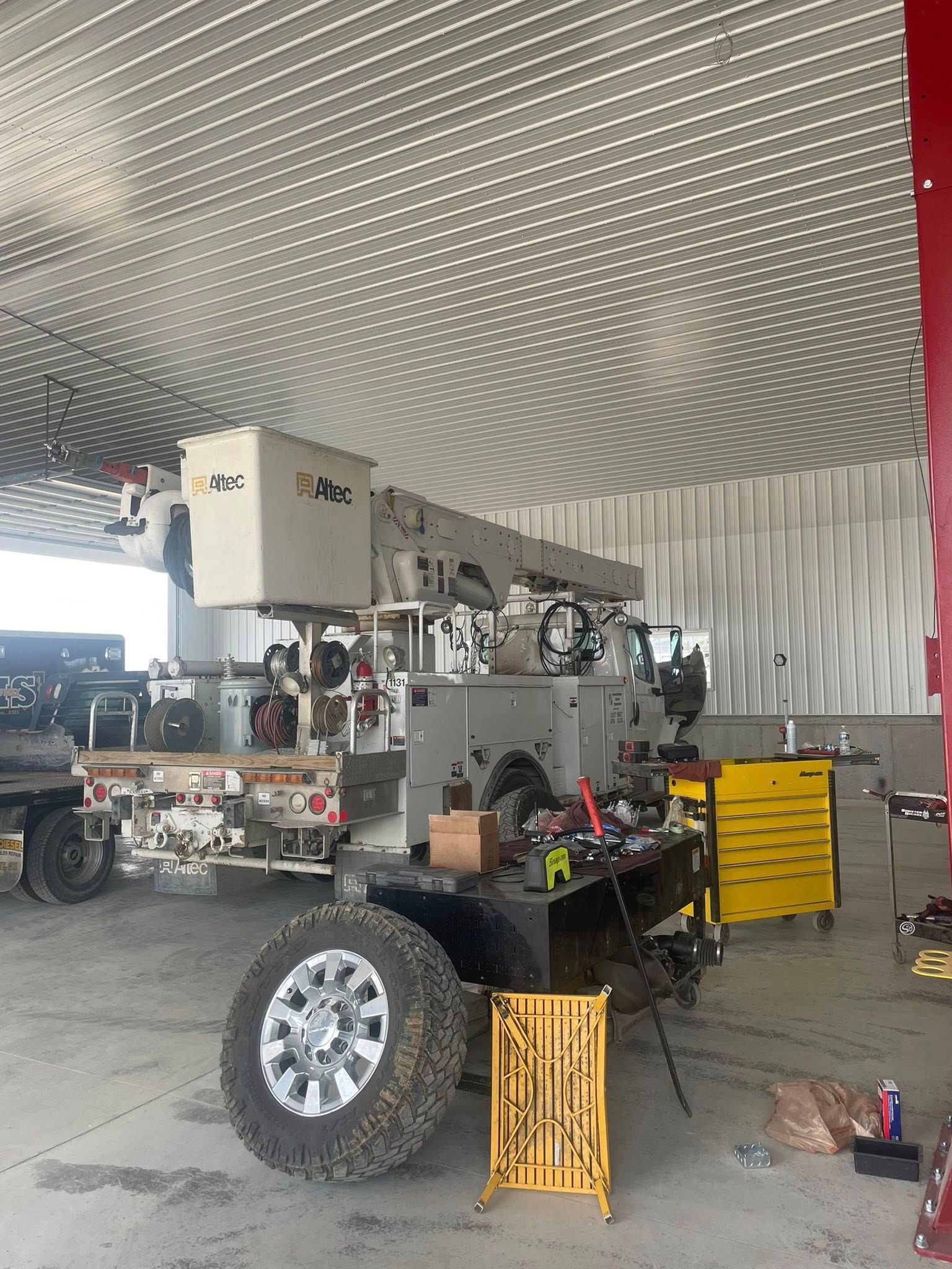 A large truck is parked in a garage next to a table.