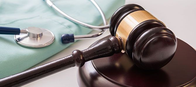 A gavel is sitting on a table next to a stethoscope