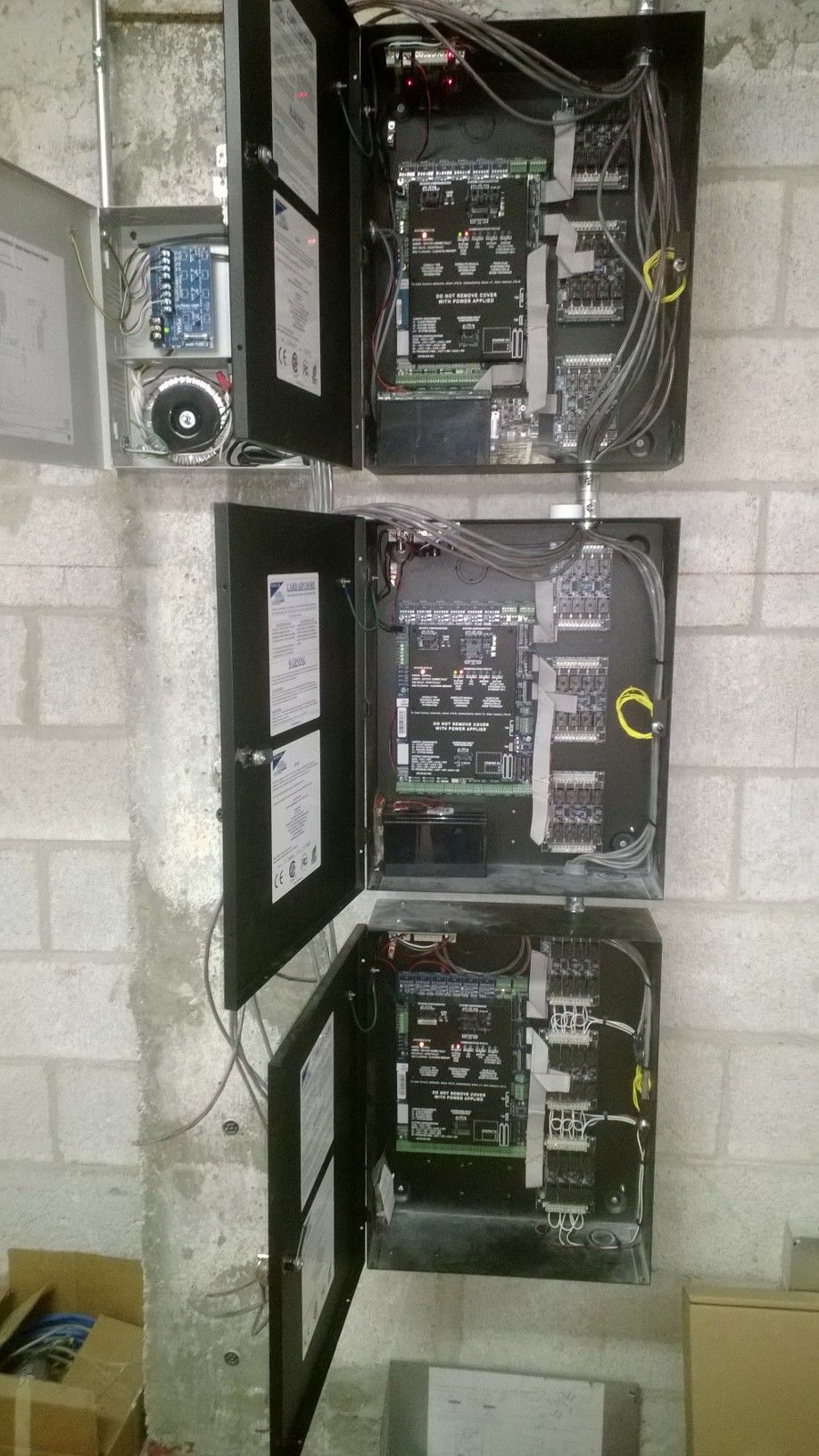 three electrical boxes are sitting on a brick wall .