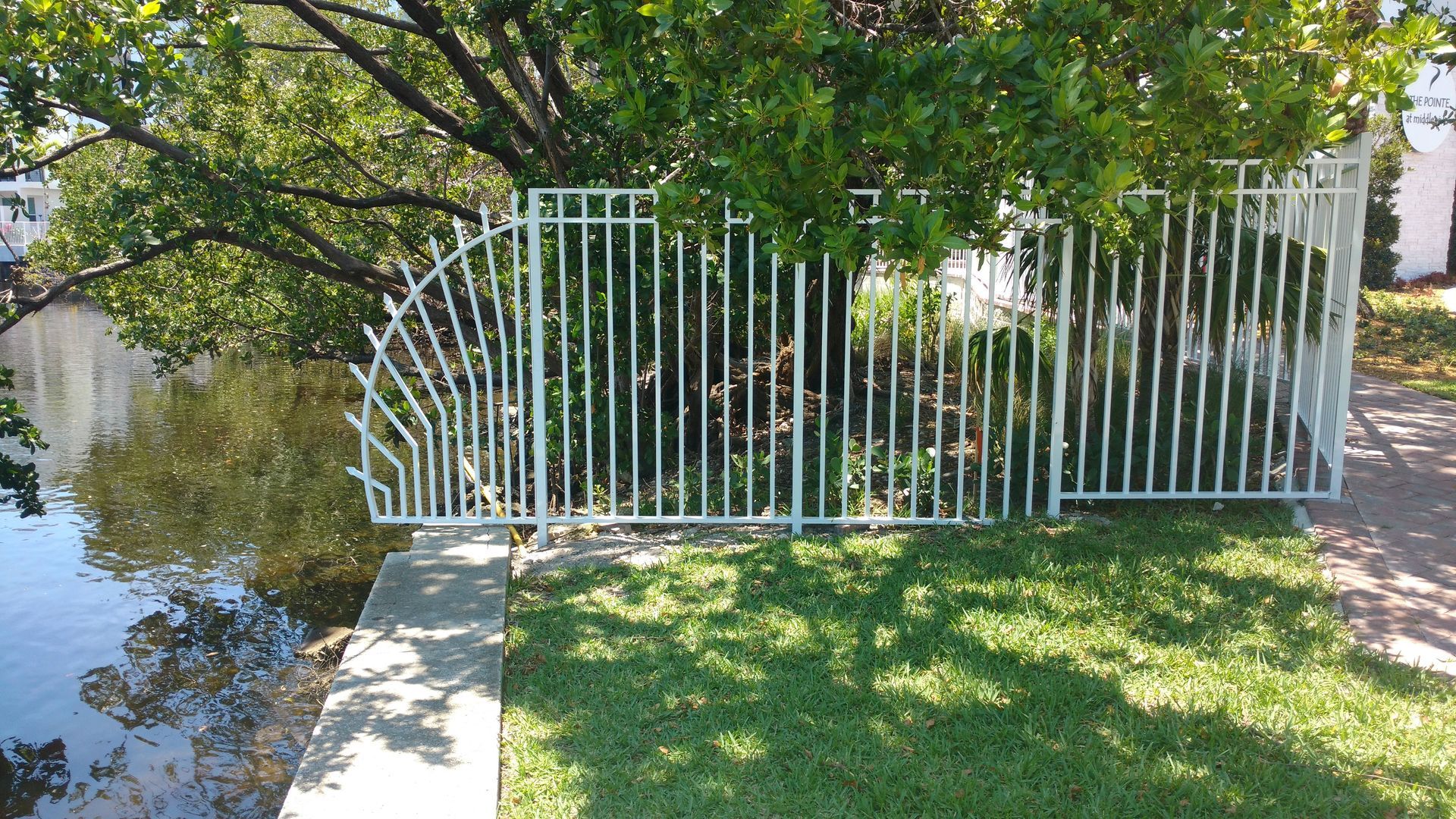 a white fence is surrounded by a flooded yard .
