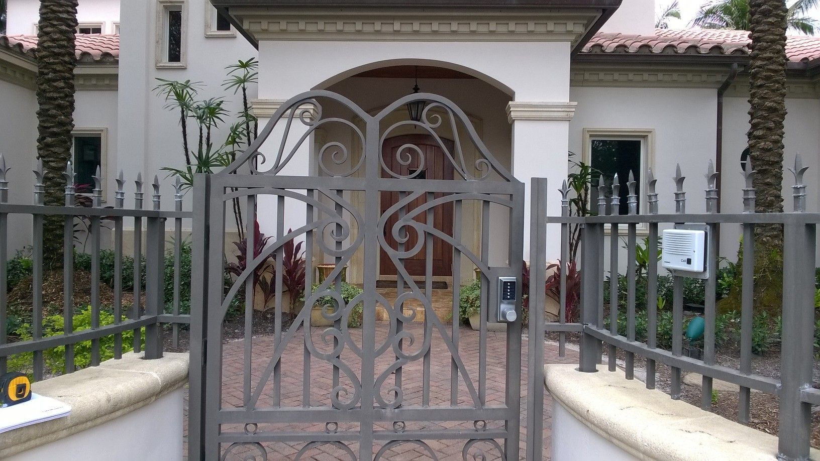 a wrought iron gate is in front of a white house