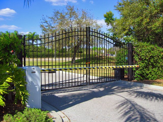 a wrought iron gate with a yellow and black stripe on it