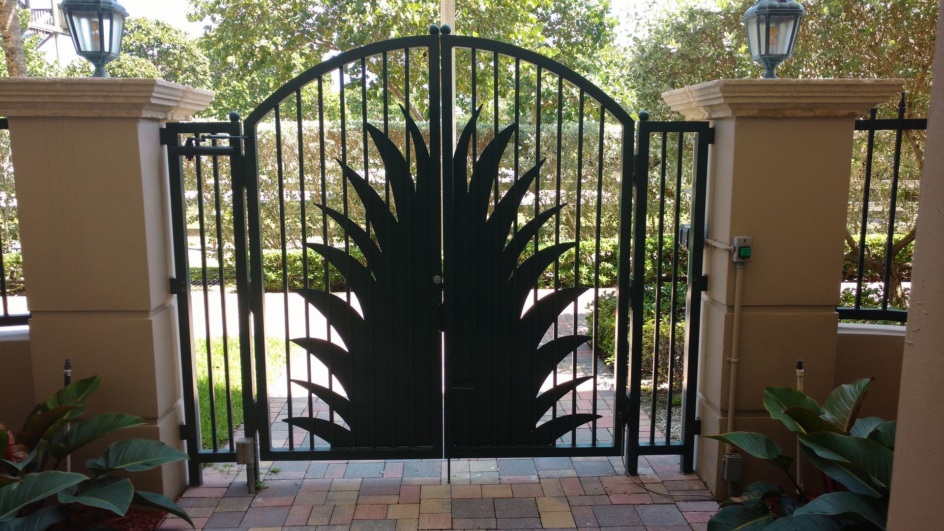 a black gate with a palm tree design on it