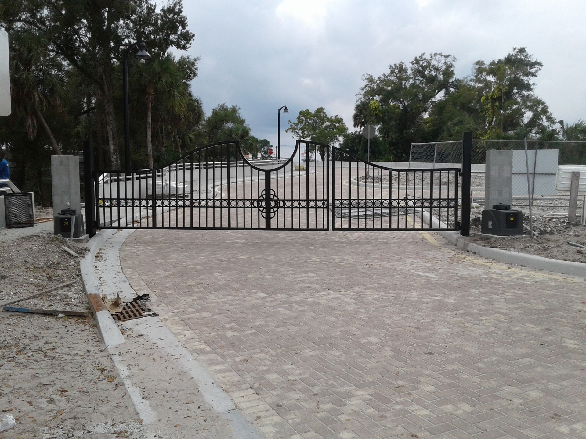 a metal gate is open to a dirt road