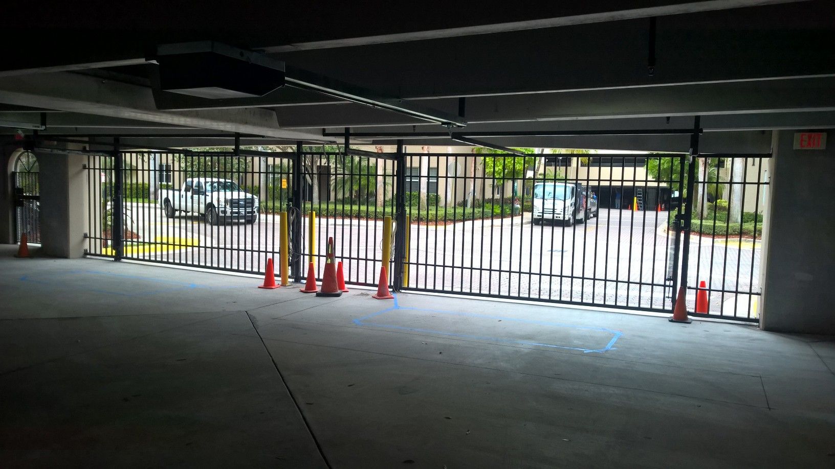 an empty parking garage with a fence and cones .