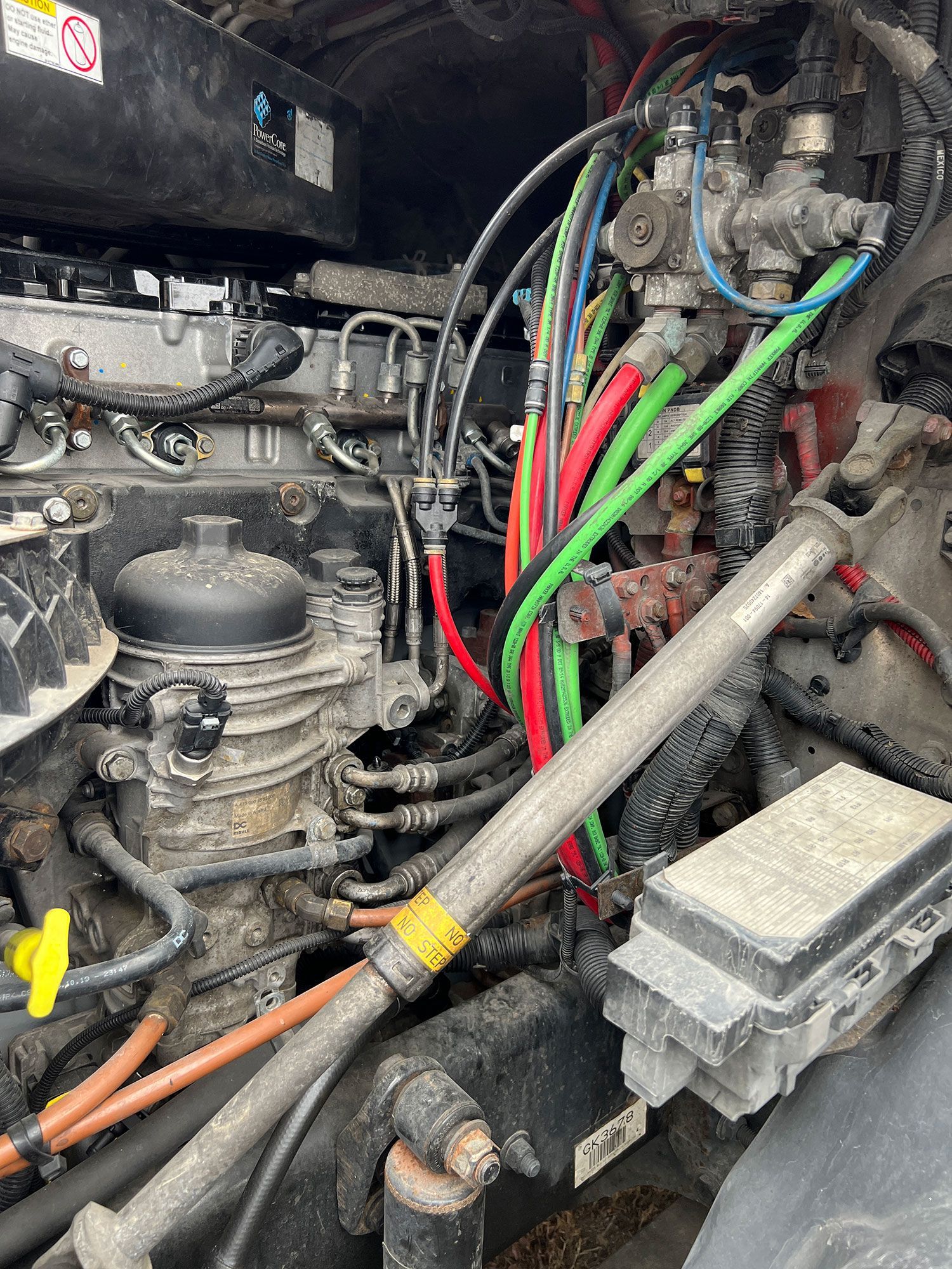 A close up of a truck engine with a lot of wires coming out of it