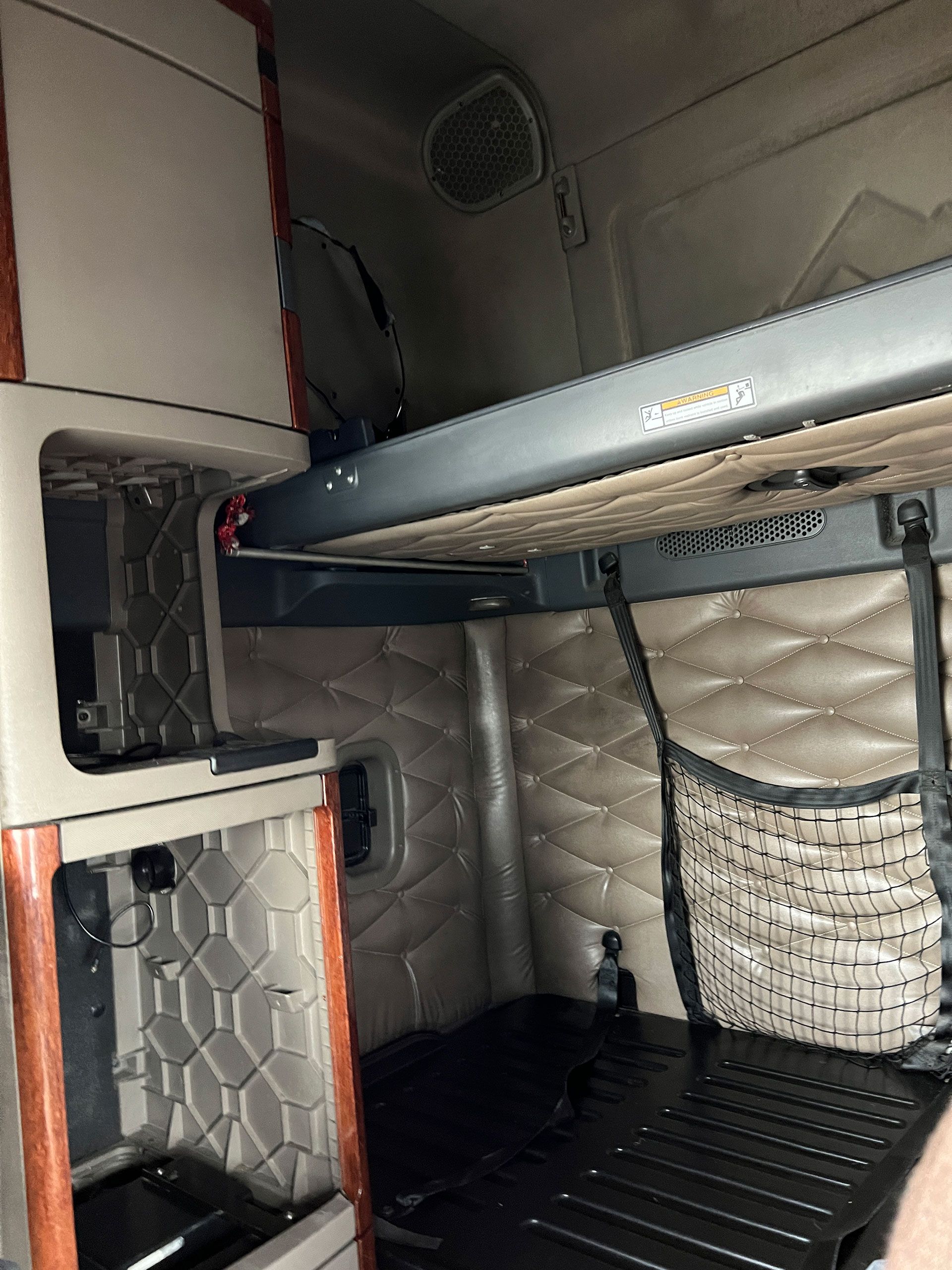 The inside of a semi truck with a bed and a ladder