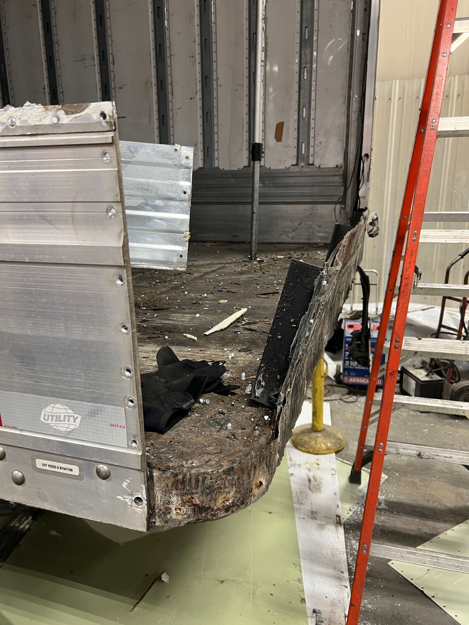 A ladder is sitting next to a truck in a garage.