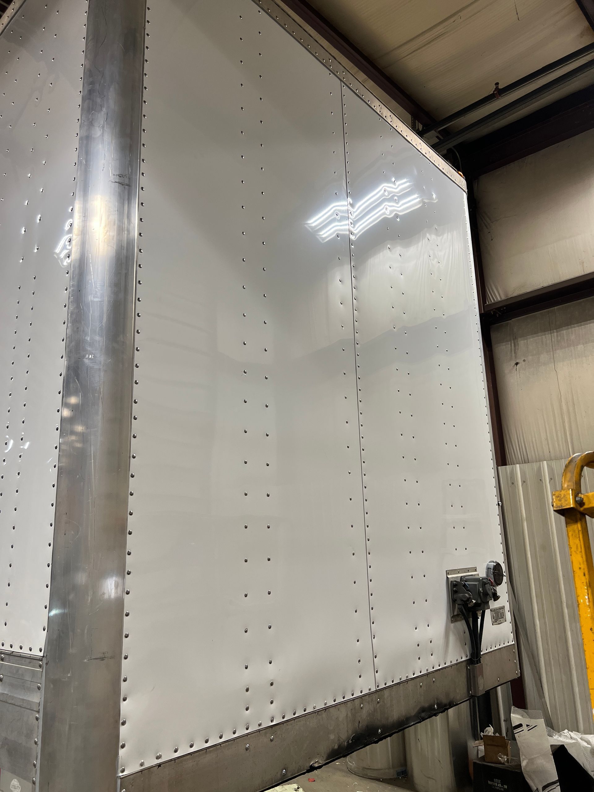 A white box with holes in it is sitting in a warehouse.