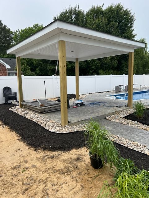 A gazebo is being built in a backyard next to a pool.
