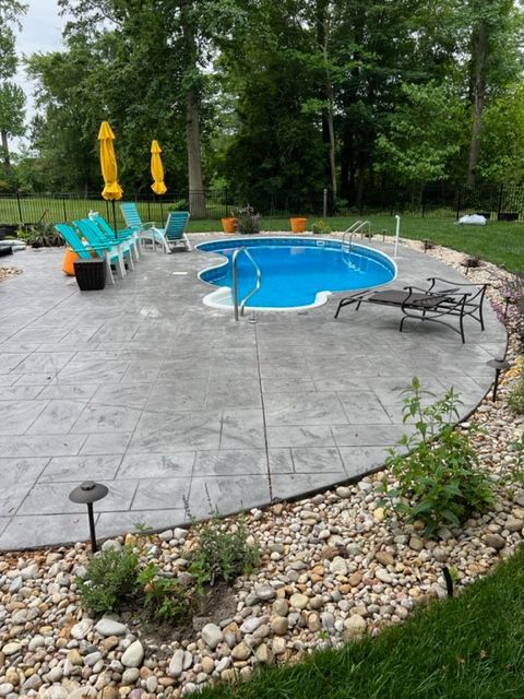 A large swimming pool surrounded by chairs and umbrellas