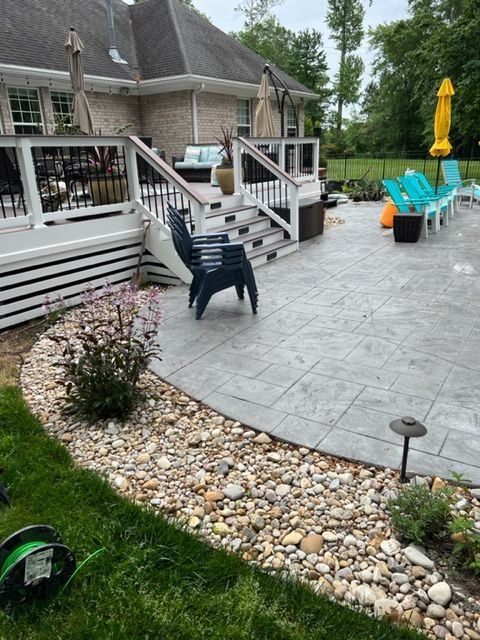 A patio with chairs and umbrellas in front of a house