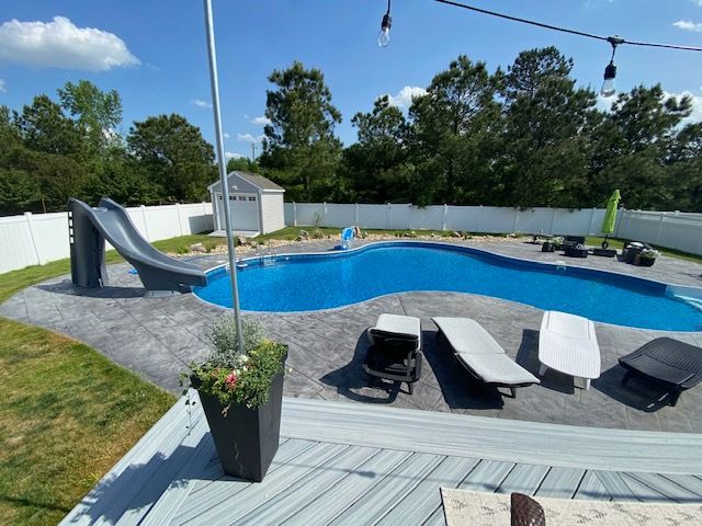 A large swimming pool with a slide in the backyard