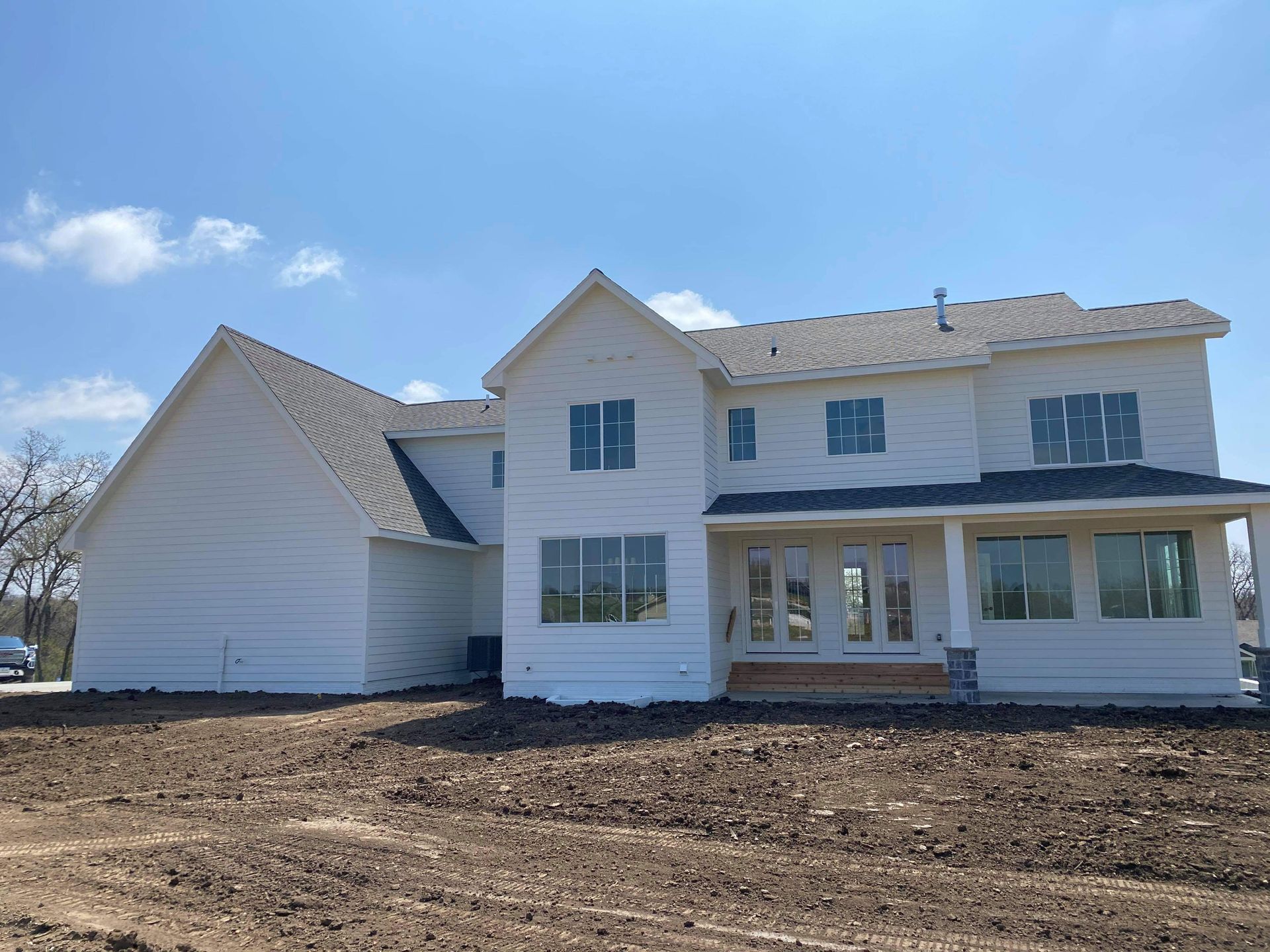 White house under construction, windows covered, blue sky overhead, dirt in foreground.