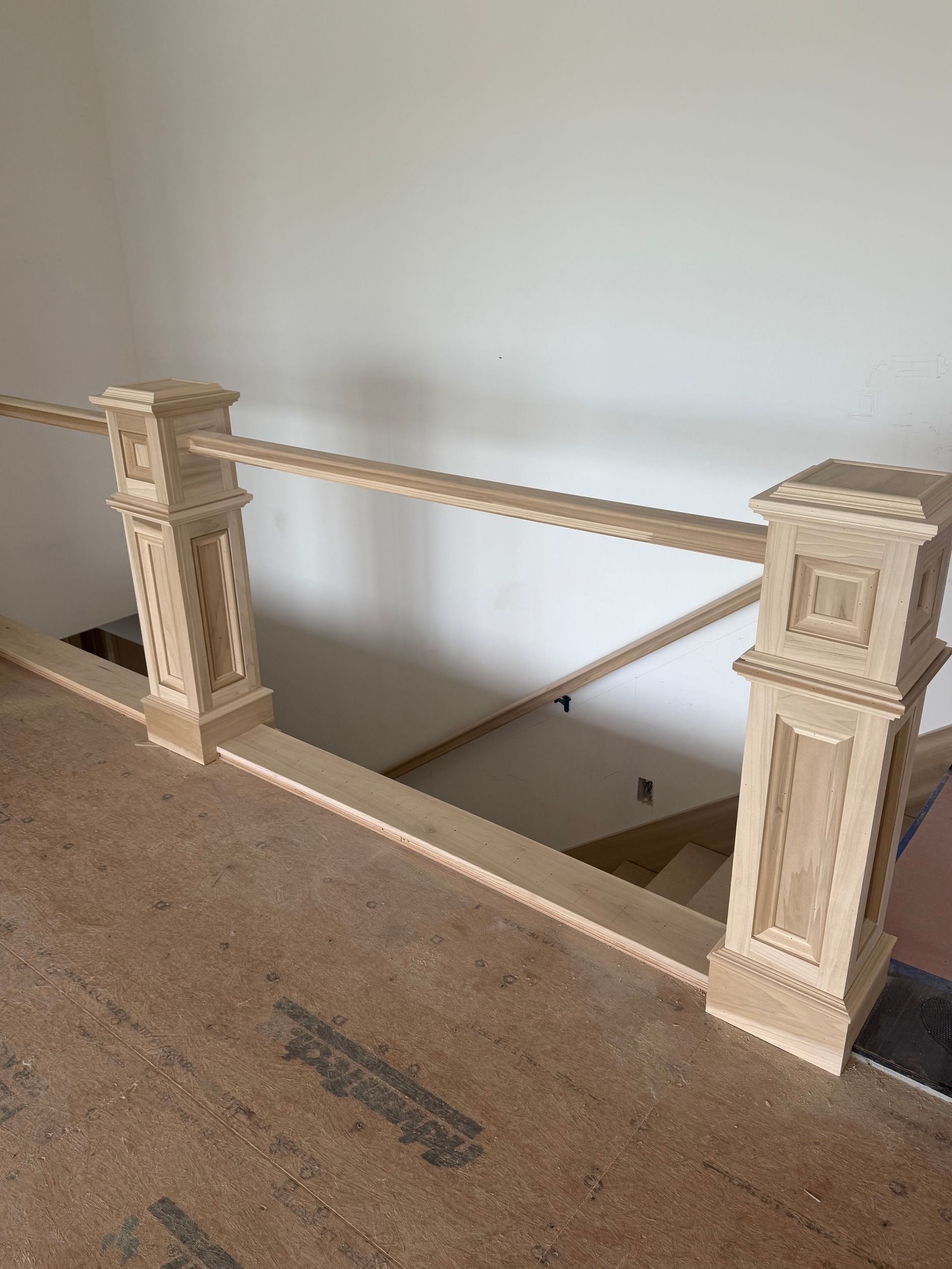 Wooden railing with two decorative posts and a horizontal rail.