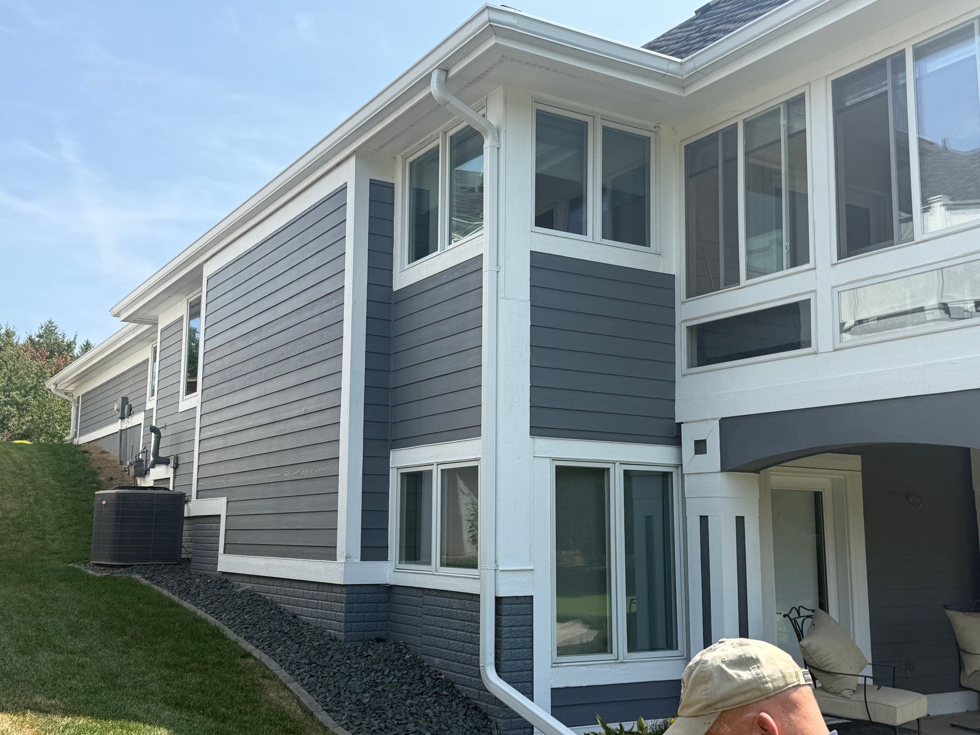 House exterior with gray siding, white trim, and multiple windows.