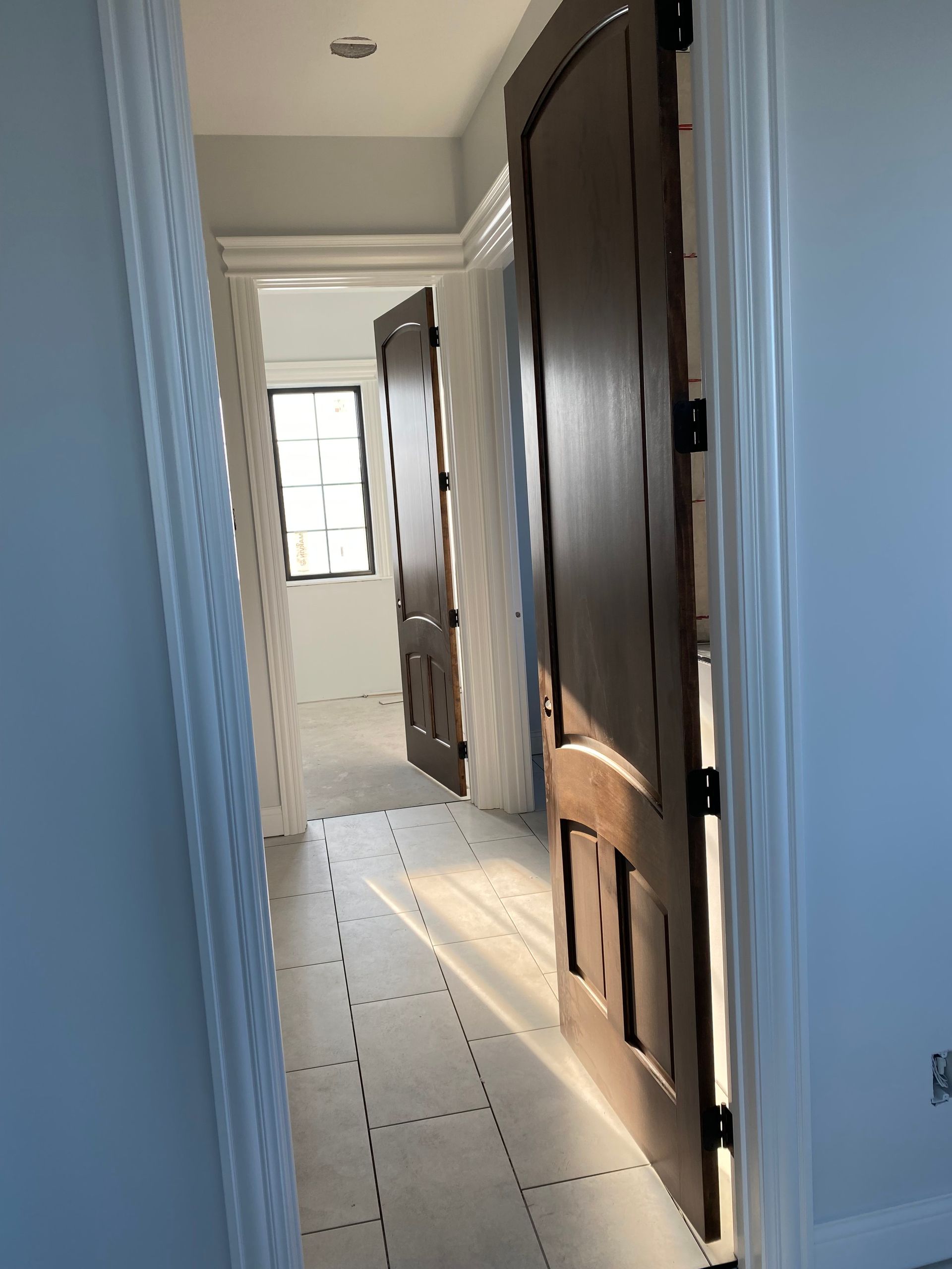 Person painting interior ceiling of a new construction home.