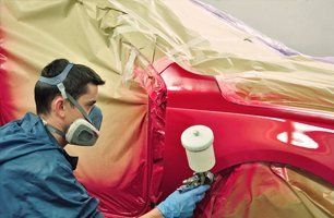 Man painting car with red